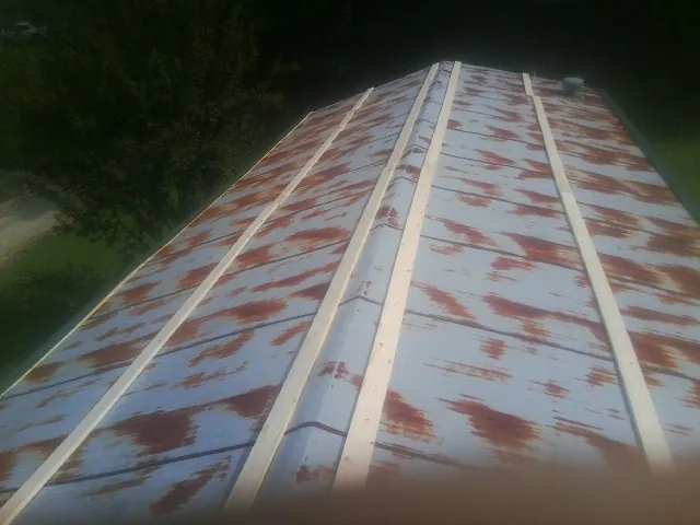 Rusted metal roof panels with new wood purlins before replacement — Storm Damage Roof Repair in Danby by Roofing Brothers