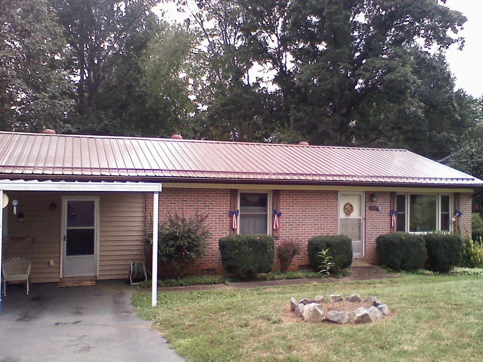 Bronze metal roof and carport on a brick ranch home — Roof Repair work by our crew in Danby